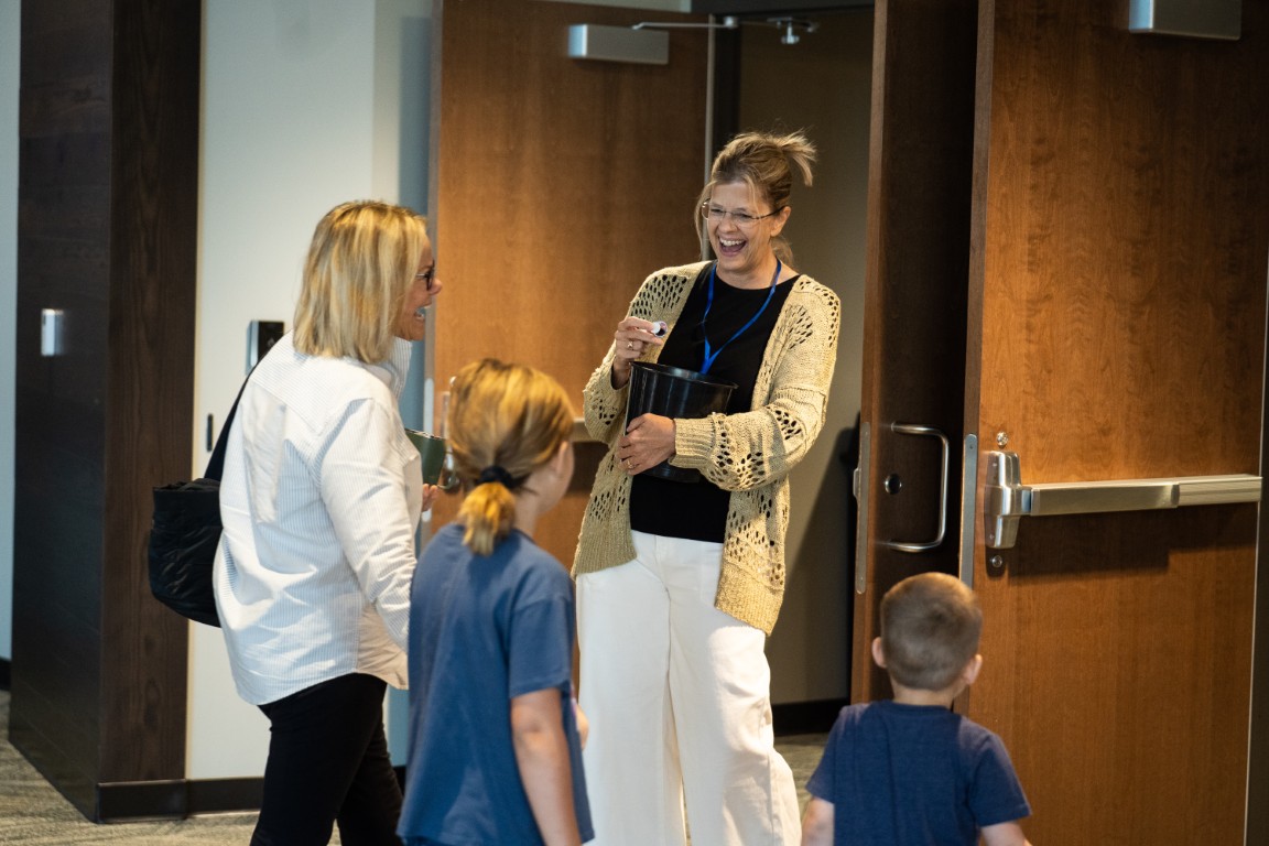 A West Side volunteer greeting a family as they arrive